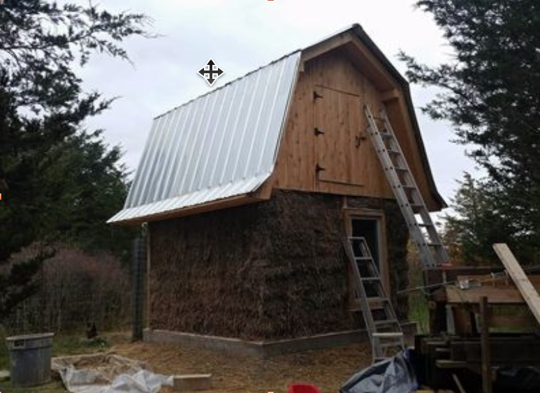 Straw bale walls fully raised on the chicken coop — the building is sealed in