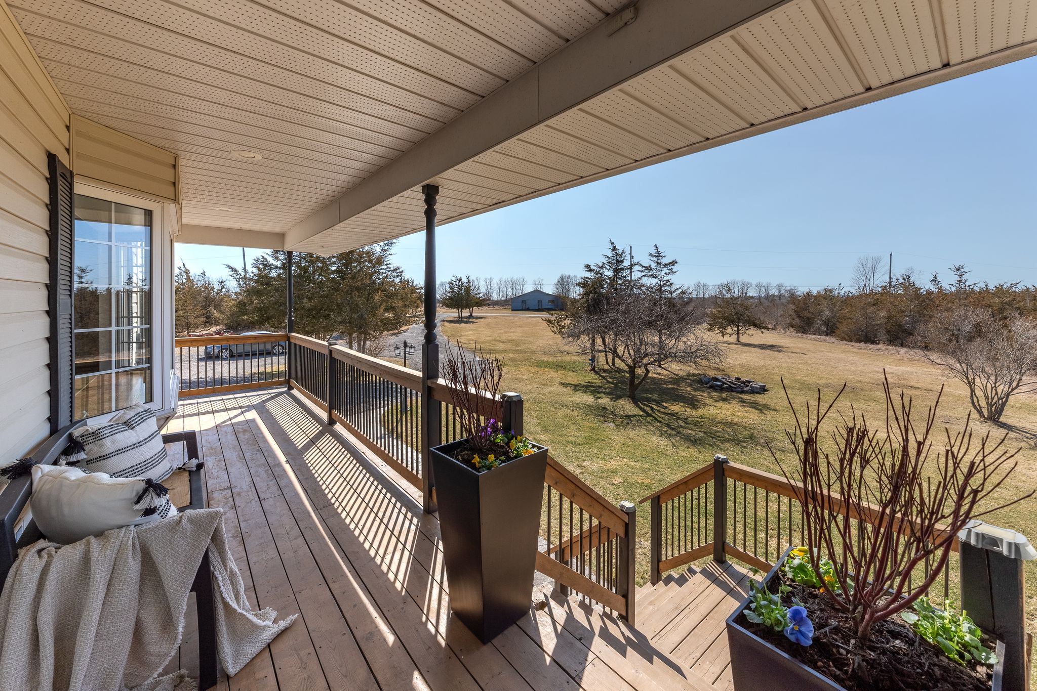 Covered porch overlooking rural property in Prince Edward County